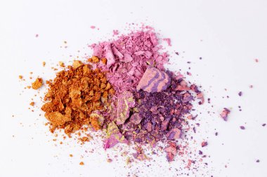 Turuncu, pembe ve mor renkli renkli renkli pigmentlerden oluşan güzel bir koleksiyon. Beyaz bir arkaplan boyunca sanatsal olarak yayılmış..