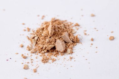 A close-up view of a pile of fine brown powder resting on a white background, showcasing its rich texture and subtle color variations in detail for artistic representation. clipart