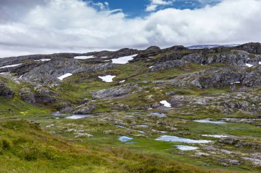 Engebeli dağların ve sakin vadilerin büyüleyici manzarası kayalık oluşumlar, canlı yeşillikler ve dramatik bulutlu gökyüzü altında yansıtıcı su havuzları sergiliyor..