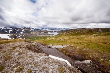 Görüntü nefes kesici bir manzara yakalıyor. Tepeler, vadiler, ve karla kaplı dağlarla çevrili sakin bir su kütlesi, saf güzelliği yansıtıyor..