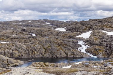Çarpıcı manzarada engebeli kaya oluşumları, çağlayan şelaleler ve sakin bir göl var. Hepsi dramatik bir gökyüzünün altında. Doğada bir sükunet hissi uyandıran güzellik..