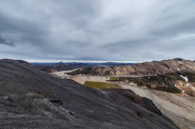 Dehşet verici bir manzara. İzlanda 'nın çarpıcı arazisini yakalıyor. Dik yamaçlar, volkanik oluşumlar, bulutların etkileşimi ve dağların üzerindeki güneş ışığı..