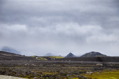 Karanlık kayalık arazi, katmanlı tepeler ve dram ve derinlik katan kasvetli gökyüzü adaları aydınlatan eşsiz volkanik manzaralar..