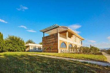 Bu büyüleyici görüntü, yemyeşil ortamda yuva yapmış eşsiz bir tasarıma sahip çağdaş bir evi gözler önüne seriyor. Bu güzel mimari atmosfer ve barışçıl çevre ile uyumludur..