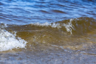 Bu büyüleyici görüntü, okyanusun uçsuz bucaksız güzelliğini ve hafif dalgaların kıyı şeridindeki rahatlatıcı etkilerini gösteren güneş ışığıyla yan yana gelen huzurlu su dalgalarını yakalar..