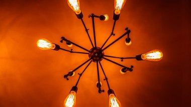 Merkezi bir merkezin etrafına yerleştirilmiş birkaç ampulden oluşan şık bir avize. Çevreye çeşitli ayarlar için ideal, sıcak ve davetkar bir parıltı saçıyor..