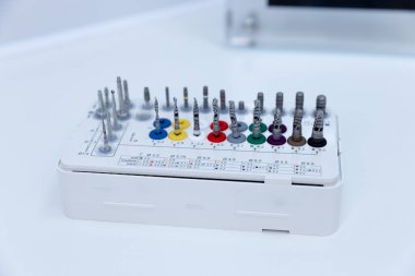 Bu resim, diş işlemleri ve tedavisinde hassasiyet için gerekli araçları sağlayarak, boyutuna göre düzenlenmiş çeşitli matkap başlıklarına sahip profesyonel bir diş matkabı biti setini gösterir.