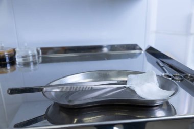 Görüntü steril bir cerrahi tepsi sunuyor. Bu tepsi, bir sağlık merkezinde cerrahi prosedürler için temiz ve düzenli bir ortam sunuyor..