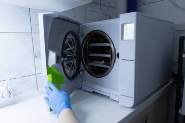 Görüntü, tibbi veya labaratuvar ortamlarında temizlik ve emniyetin saglanmasi için titiz sterilizasyon süreçleri için tasarlanmis modern bir sterilizasyon cihazini gosteriyor..