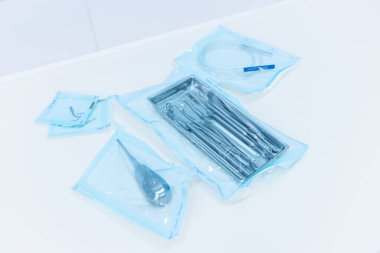 Bu resimde steril tıbbi aletler titizlikle hazırlanmış, klinik ayarlar ve cerrahi prosedürler için ideal bir dizi koruyucu ambalaj sergilenmektedir..