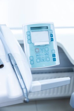 Diş hekimi kullanımı için tasarlanmış diş hekiminin kontrol panelinin kapanışı, hastalar için verimli ve konforlu diş prosedürleri sağlamak için çeşitli düğme ve ayarlar sergileniyor.