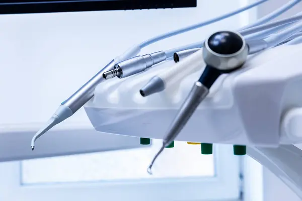 Bu resim, hasta bakımı ve oral sağlıkta modern dişçilikte kullanılan hassas araçları vurgulamak üzere diş aletlerinin düzenli bir şekilde yerleştirildiği bir koleksiyonu gösteriyor..