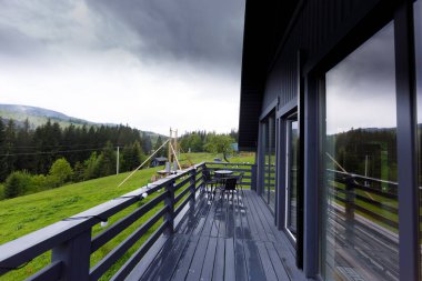 Görüntü, kayan tepelerin ve yoğun ormanların atmosferik bulutlarla çevrili panoramik görüntülerini sunarak, barışçıl bir geri çekilme yaratıyor..