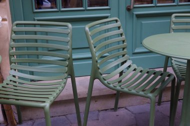 Yuvarlak bir masa ile birleştirilmiş iki zarif yeşil sandalye açık havada bir kafe atmosferi yaratır. Kahveyi yudumlamak ya da rahatça sohbet etmek için mükemmel..