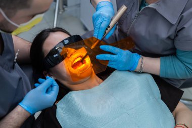 Uzman diş hekimliği personeli tarafından geliştirilmiş ekipman, bakım ve diş hekimliği teknolojisi kullanılarak ameliyat edilen bir hastanın diş tedavisi sahnesinin genel görünümü.