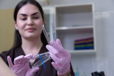 Modern bir salonda, pembe eldivenli kendini adamış bir profesyonel güzellik aletlerini inceliyor, güzellik endüstrisinde hijyen ve güvenliğe olan yeteneğini ve bağlılığını gösteriyor..