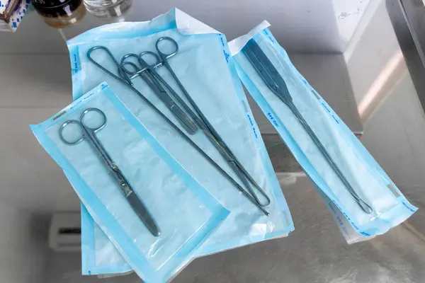 Görüntü, düzenli bir şekilde paketlenmiş çeşitli cerrahi aletleri gösteriyor ve hasta güvenliği için tıbbi prosedürlerde temizlik ve hazırlığın önemini vurguluyor..
