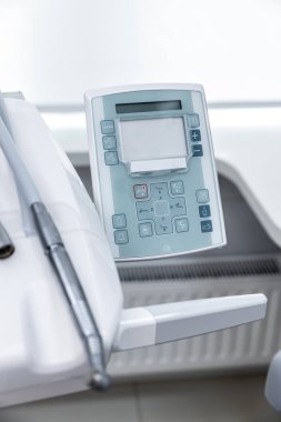 Hasta bakımı ve tedavisinde uzmanlar için tasarlanmış çeşitli kullanıcı arayüzü düğmelerini gösteren çok işlevli bir diş kontrol panelinin yakın plan görüntüsü.