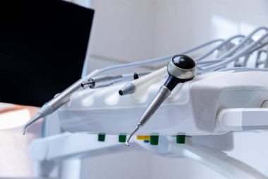 Çağdaş bir klinik ortamında oral sağlık prosedürlerinde kullanılan hassas ekipmanları gösteren diş sağlığı aletleri ve aletlerinin yakın plan görüntüsü..
