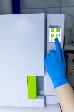 Mavi eldiven giyen bir el, bir laboratuvar buzdolabının dijital arayüzü ile etkileşime girer, sıcaklık ayarları ve örnek yönetim için kullanıcı dostu seçenekler gösterir.