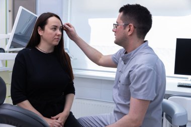 Bir kadın, iyi aydınlatılmış, modern bir klinikteki yetenekli bir klinikten bireyselleştirilmiş estetik tedavilere odaklanan ve kendine güvenini artıran kişiselleştirilmiş bir danışmanlık alır..