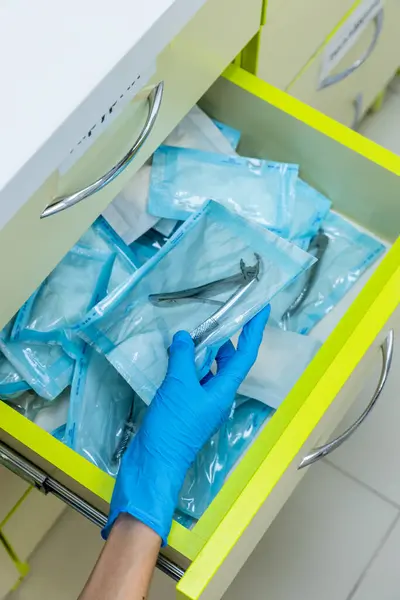 Görüntü, hasta güvenliği için temizlik ve organizasyonun önemini vurgulayan sterilize edilmiş diş aletleriyle dolu bir çekmece gösteriyor..