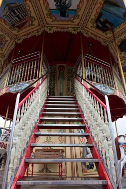 Bu fotoğraf dekoratif unsurlar, canlı renkler ve ziyaretçileri sunduğu garip deneyimin tadını çıkarmaya davet eden bir merdivenin süslü girişini gösteriyor..