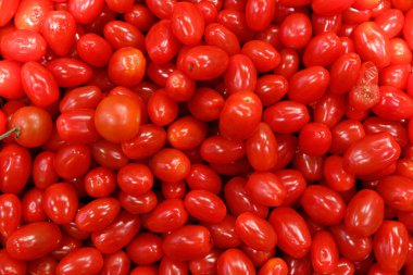 Taze yemekler, salatalar ve sağlıklı yemekler için ideal canlı kırmızı domateslerini ve dolgun dokularını gösteren olgun, sulu vişne domateslerinin yakın çekim görüntüsü..