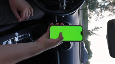 Dikey video Bu video birçok sahne gösteriyor Bir el bir arabanın içinde yeşil ekran ile bir akıllı telefonu tutuyor, çeşitli açıları ve perspektifleri dinamik bir şekilde yakalıyor.