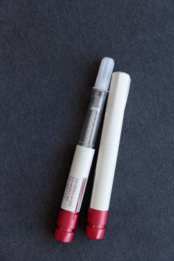 Bu resimde kan koleksiyonu için tasarlanmış iki laboratuvar tüpü var. Kapağı açık bir tüp ve koyu renk yüzey hormonal uyarımları içeren kırmızı bir tüp. Yumurtalık prosedürleri.