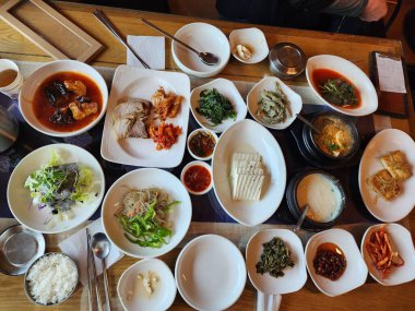 İçinde kimchi, baharatlı sebze, turp turşusu ve marine edilmiş yosun bulunan renkli bir banchan çeşidi. Bu Kore mezeleri masaya çeşitli dokular ve tatlar getiriyor..