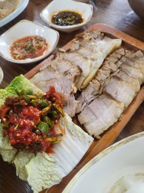 Yumuşak bir parça Bossam, Kore haşlanmış domuz göbeği, taze marul, sarımsak ve ssamjang ile servis edilir. Bu lezzetli ve lezzetli yemek geleneksel bir Kore yemeğini paketlemek ve paylaşmak için mükemmeldir..