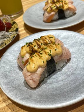 Çeşitli malzemeler ve canlı renklerle sanatsal olarak düzenlenmiş taze suşi çeşitleri. Bu geleneksel Japon yemeği bir deneyim için sirkeli pirinç, deniz ürünleri ve sebzeleri birleştirir..