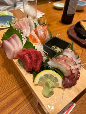 Taze ve narin sashimi dilimleri, canlı renkler ve mükemmel kesimlerle güzelce sunuluyor. Bu geleneksel Japon lezzeti kaliteli deniz ürünlerinin saf tatlarını vurgular..