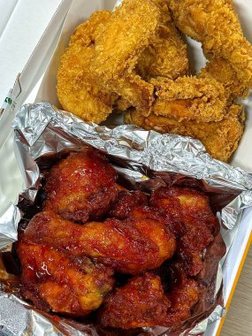 Kızarmış Kore tavuğu, tatlı ve baharatlı sosla mükemmel bir şekilde jölelenmiş. Yemek fotoğrafçılığı ve menüler için idealdir. Bu sevilen yemeğin dayanılmaz çıtırtısını ve lezzetini sergiler..