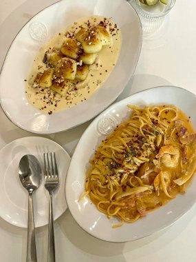 Bir tabak spagetti makarnası, mükemmel pişirilmiş ve üzerine bol marinara sosu ve taze otlar konmuş. Yemek fotoğrafçılığı ve menüler için ideal, İtalyan mutfağının kalbini lezzetli bir şekilde yakalamak..