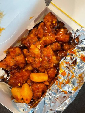 Kızarmış Kore tavuğu, tatlı ve baharatlı sosla mükemmel bir şekilde jölelenmiş. Yemek fotoğrafçılığı ve menüler için idealdir. Bu sevilen yemeğin dayanılmaz çıtırtısını ve lezzetini sergiler..