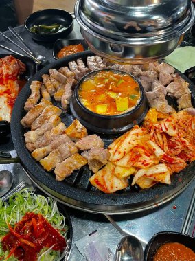 Izgara samgyeopsal, kalın domuz eti dilimleri çıtır çıtır ve taze et. Klasik bir Kore barbekü deneyimi için marul, sarımsak ve sosla servis ediliyor..