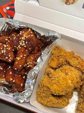 Kızarmış Kore tavuğu, tatlı ve baharatlı sosla mükemmel bir şekilde jölelenmiş. Yemek fotoğrafçılığı ve menüler için idealdir. Bu sevilen yemeğin dayanılmaz çıtırtısını ve lezzetini sergiler..