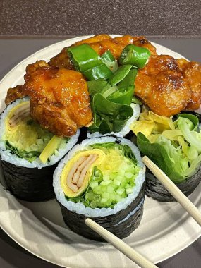 Kimbap ve dakgangjeong 'un enfes bir karışımı. Kıtır kıtır, tatlı ve baharatlı Kore usulü kızarmış tavuklar leziz pirinç dürümleriyle mükemmel bir lezzet ve tatmin edici bir yemek yaratıyor..