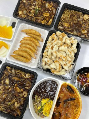 Zengin siyah fasulye sosuna bulanmış kalın, çiğnenmiş erişteli klasik Kore-Çin karışımı, yanında gevrek tangsuyuk, bol yağda kızartılmış domuz eti ve tatlı ve ekşi sos servis edilir..