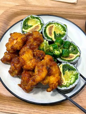 Kimbap ve dakgangjeong 'un enfes bir karışımı. Kıtır kıtır, tatlı ve baharatlı Kore usulü kızarmış tavuklar leziz pirinç dürümleriyle mükemmel bir lezzet ve tatmin edici bir yemek yaratıyor..