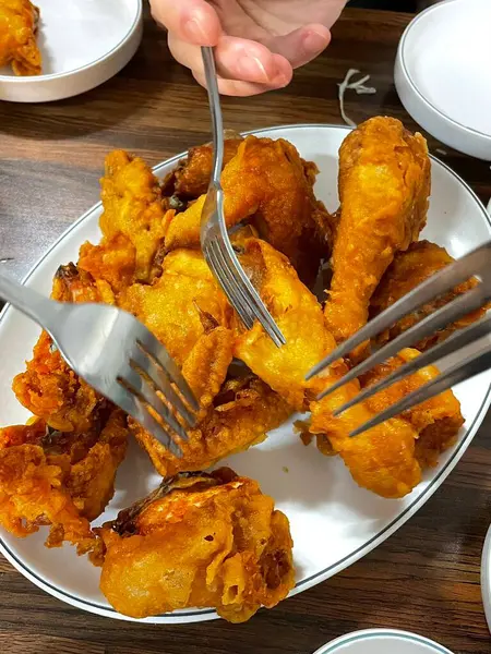 Kızarmış Kore tavuğu, tatlı ve baharatlı sosla mükemmel bir şekilde jölelenmiş. Yemek fotoğrafçılığı ve menüler için idealdir. Bu sevilen yemeğin dayanılmaz çıtırtısını ve lezzetini sergiler..