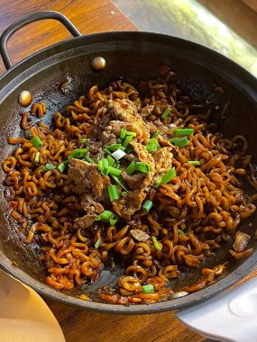 Yeşil soğan ve susamlı fasulye soslu baharatlı japagetti eriştesi. Her ısırıkta derinlik ve lezzeti birleştiren rahatlatıcı bir Kore favorisi..