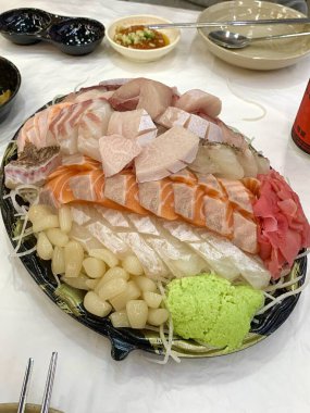 Taze ve narin sashimi dilimleri, canlı renkler ve mükemmel kesimlerle güzelce sunuluyor. Bu geleneksel Japon lezzeti kaliteli deniz ürünlerinin saf tatlarını vurgular..