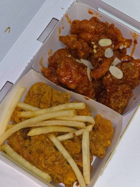 Tatlı ve baharatlı soslu kızarmış Kore tavuğu, yanında da altın patates kızartması. Her lezzetli lokmada mükemmel bir lezzet ve tatminkar kıtır kıtır..