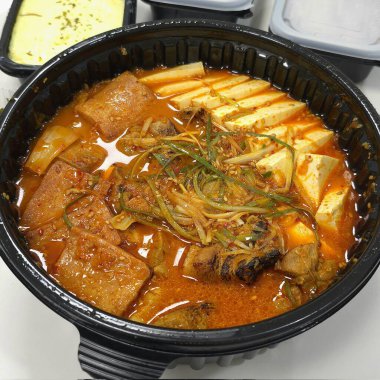 Baharatlı bir çorbada sosis, tofu, kimchi ve erişte ile dolu doyurucu bir kase Budaejjigae (Kore Ordu Güveci). Bu lezzetli yemek sıcaklık ve rahatlık getirir. Paylaşmak için mükemmel..