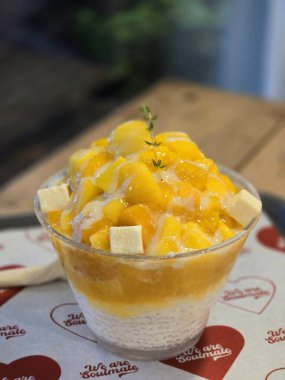 Tüylü buzlu mango bingsu, tatlı mango parçaları ve yoğun sütlü krema. Sıcak günler için mükemmel bir Kore tatlısı, lezzetli meyveli ve kremalı tatlar dengesi sunuyor.!