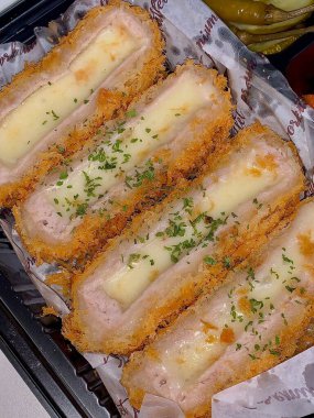 Erimiş peynirle doldurulmuş çıtır tonkatsu pirzolası, kıtır kıtır ve kremanın lezzetli bir karışımını oluşturuyor. Zengin ve altın kaplamalı rahatlatıcı bir yemek..