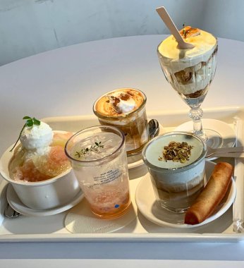 Hoş bir kafe ortamında sergilenen tatlı çeşitleri zarif tabaklar üzerinde pastalar, pastalar ve tatlı ikramlar, sıcak ve davetkar bir atmosfer yaratıyor..